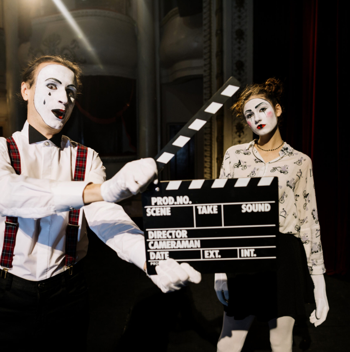 male-mime-artist-holding-clapperboard-front-female-mime-artist